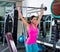 Brunette girl wide grip barbell shoulder press gym