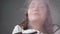 Brunette-haired woman enjoying moist air from humidifier