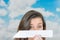 Brunette holding a paperplane in front of cloud