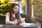 Brunette intelligent girl studying in cafe, holding smartphone