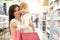 Brunette keeping child on hands and shopping in store