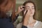 Brunette make up artist woman applying make up for a caucasian b