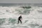 Brunette man in the swimsuit professionally riding on a surf on the sea