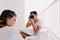 Brunette man with trendy hairstyle making photo of his beautiful girlfriend, while resting in weekend on balcony