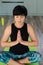 Brunette middle aged woman doing yoga meditation on exercise mat at home, mental health. Peaceful woman meditate, mental