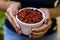 Brunette model hand holding white pot with goji berry