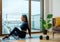 Brunette with ponytail practices yoga on glazed balcony