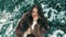 Brunette rich woman waist coat of brown fur on background of Christmas tree slow motion