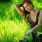 Brunette sitting on green grass
