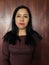 brunette skin mexican woman with brown sweater posing with wooden background