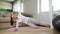 Brunette sportswoman does exercises standing in side plank