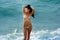 Brunette standing in surf