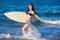 Brunette surfer girl running in the beach