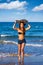 Brunette surfer teen girl holding surfboard in a beach