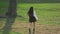 Brunette walks on grassy meadow in slow mo. Model has nice legs and short skirt.