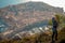 Brunette wearing blue jeans and blue top seen from behind standing on the mountain above the city of Dubrovnik, amazing town seen