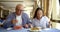 Brunette woman and bald man are lunching in cafe in daytime, enjoying meal