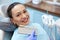 Brunette woman with beautiful smile before receiving dental care check up and teeth whitening bleaching, dentist wearing exam