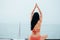 Brunette woman in bikini sitting on lotus yoga pose on boat