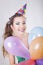 Brunette Woman in a Birthday Cap Holding Balloons and Smile