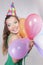 Brunette Woman in a Birthday Cap Holding Balloons and Smile