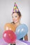 Brunette Woman in a Birthday Cap Holding Balloons and Smile