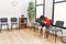 Brunette woman with down syndrome sitting covering face at waiting room