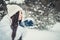 Brunette woman is happy and blowing snow in the winter nature