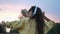 Brunette woman in headphones dancing in wheat field in summer sunset time. slow motion