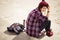 Brunette woman in hipster outfit sitting on steps on the street. Toned image