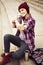 Brunette woman in hipster outfit sitting on steps and taking selfie on phone on the street. Toned image