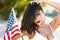 brunette woman holding USA flag outdoor