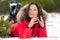 Brunette woman lies on snowdrift in winter pine forest, looks to side and smiles