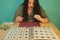 Brunette woman with a magnifying glass looking through her numismatic collection