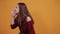 Brunette woman in maroon dress in studio screaming, inviting for talk.