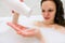 Brunette woman pouring shampoo on hand in shower