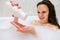 Brunette woman pouring shampoo on hand in shower