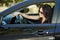 Brunette woman sitting in car, beautiful female driver