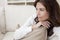 Brunette Woman Sitting Thinking At Home on Sofa