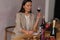 Brunette woman sommelier tasting smelling wine and writing notes.