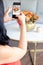 Brunette woman is taking a photo of a cute floral bouquet inside a cabbage-painted pumpkin.