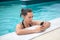 Brunette woman texting from swimming pool