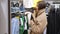 Brunette woman in a warm beige wool coat stands in front of a mirror in a store