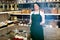 Brunette woman wearing apron and selling nuts