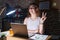 Brunette woman working at the office at night smiling with happy face winking at the camera doing victory sign