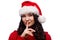 Brunette woman in xmas santa hat with finger on lips as concept of ordering silence, isolated