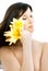 Brunette with yellow lily flowers in spa