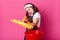Brunette young housewife with directed yellow mop and red bucket. Brown apron. Happy woman works at home. Hardworking female