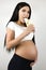 Brunette young pregant woman eats shawarma on  white background