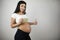 Brunette young pregant woman holding vitamins in her hand showing like sign on  white background